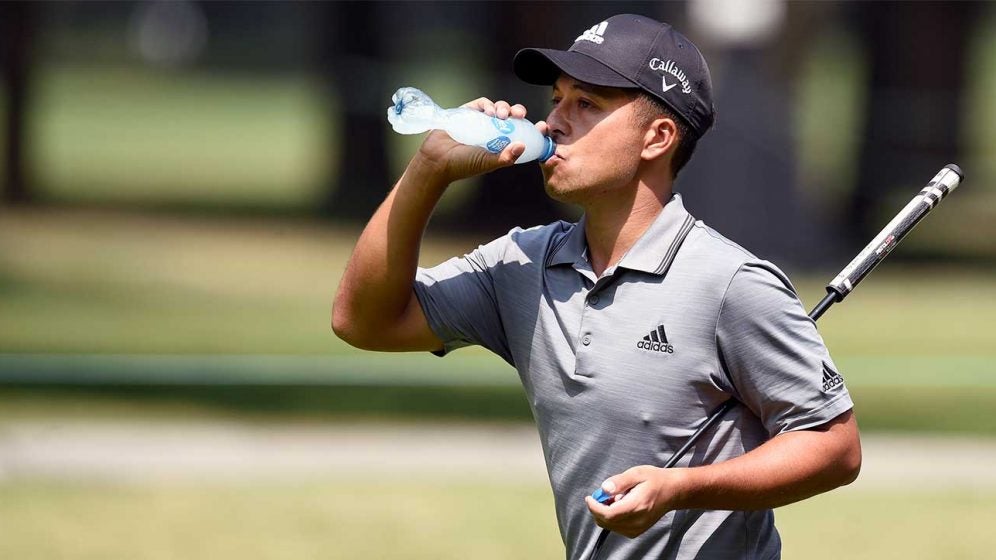 Xander Schauffele takes a swig of water during an event.