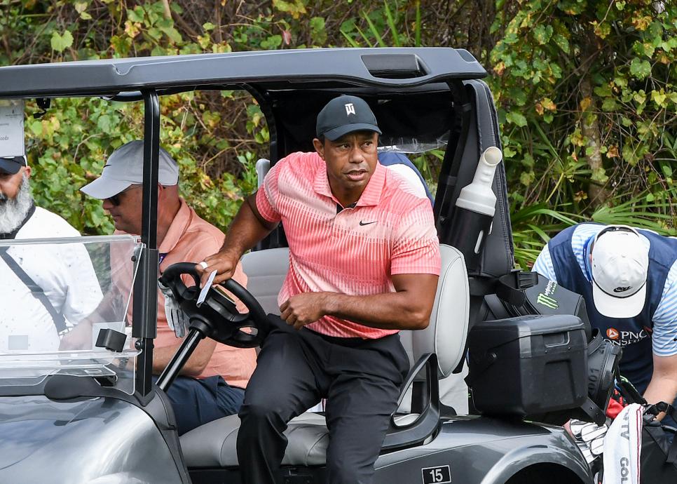 Tiger Woods kliver ur en golfbil i rosa tröja